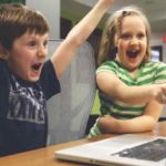 パソコン画面をみて喜ぶ男の子と女の子